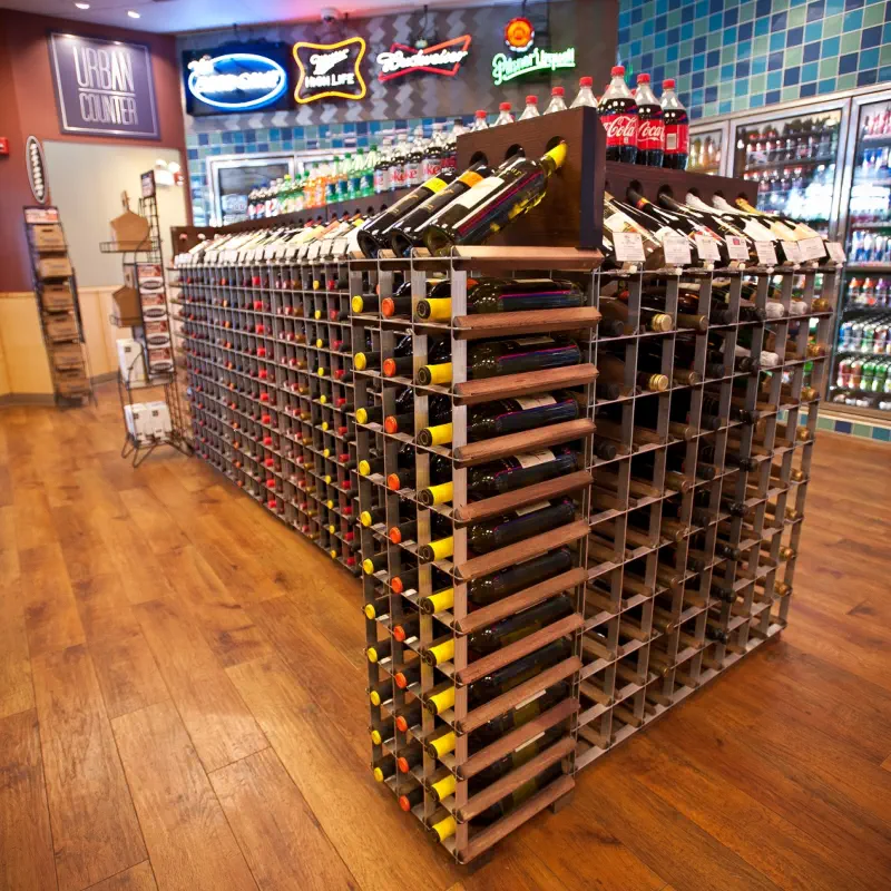 Double-sided aisle wine racks forming a free-standing island wine display near the Urban Counter restaurant inside a PRIDE Stores location